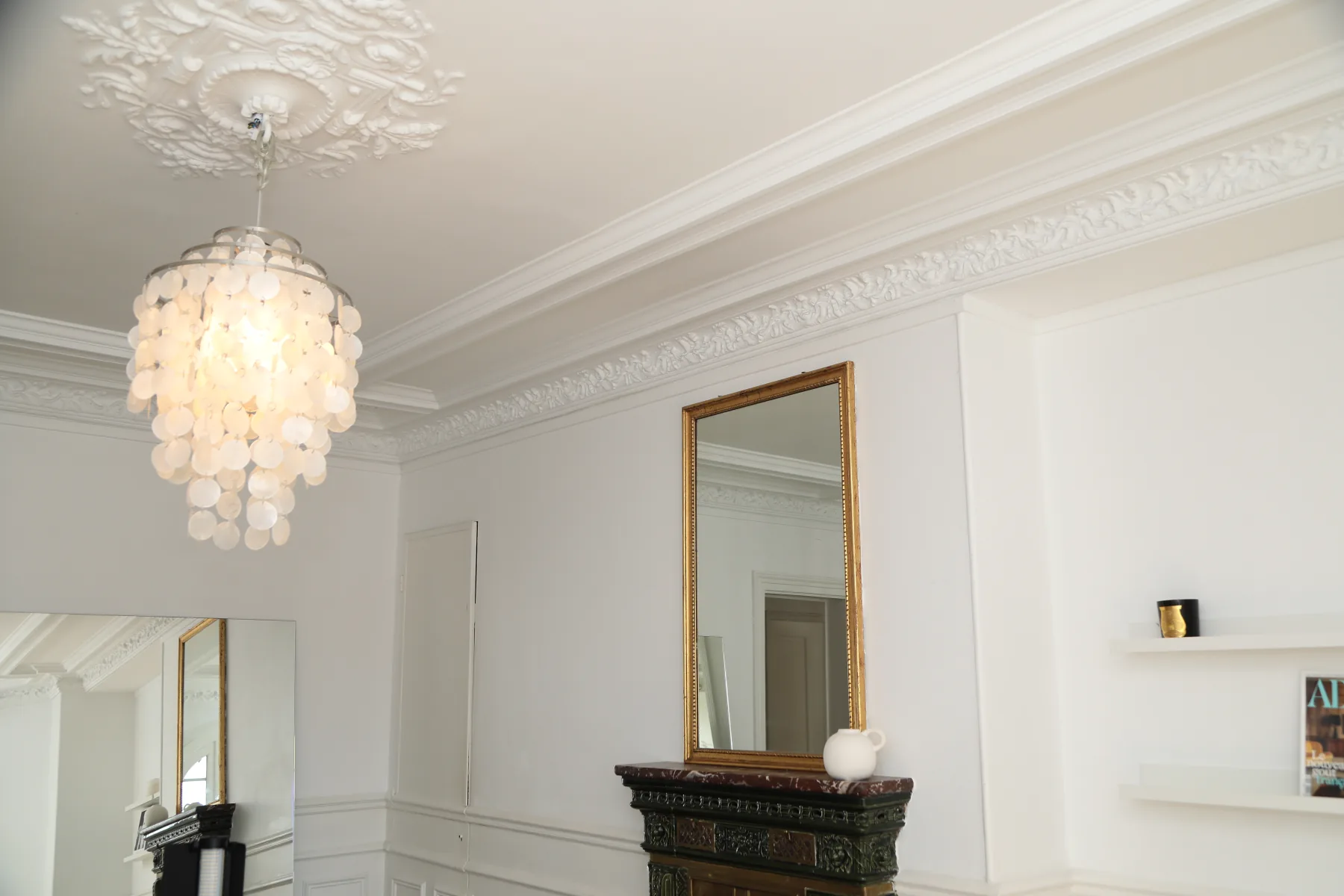 Lustre cristal et moulures — appartement haussmannien rénové par Maison Arkéa